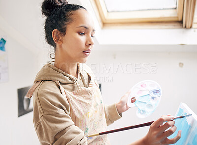 Buy stock photo High angle shot of an attractive young woman painting on a canvas in her studio