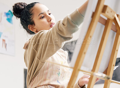 Buy stock photo Young woman, painting and easel in creative studio for art project, student and canvas. Artist, watercolor and design workshop for learning, exhibition and gen z girl with talent in apartment