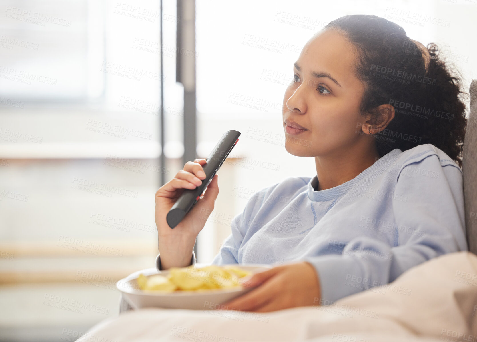 Buy stock photo Cropped shot of an attractive young woman watching TV at home