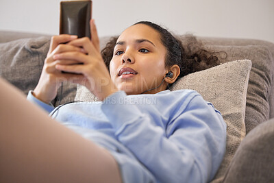 Buy stock photo Woman, sofa and relax with smartphone or earphones with listening to podcast, music or streaming movie. Day off, weekend and unwind at home with mobile for chatting on couch in apartment for fun