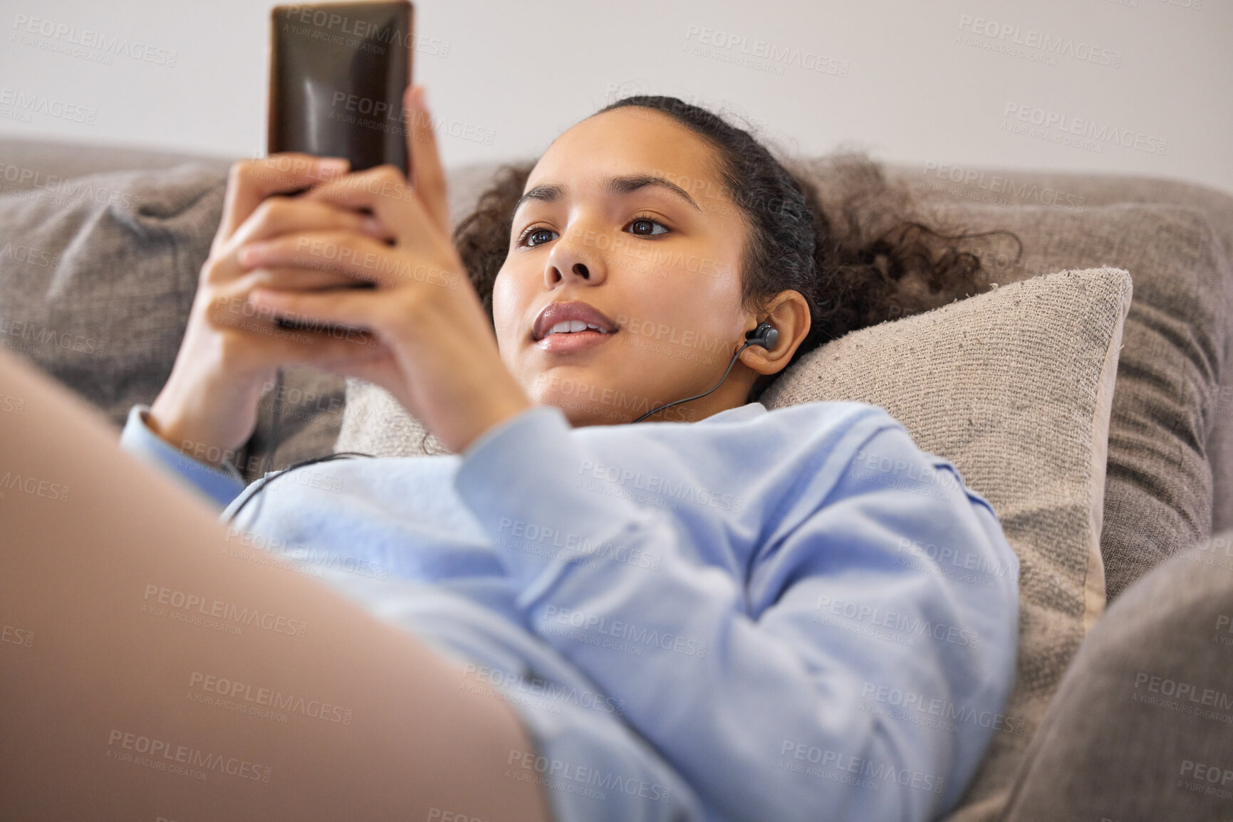 Buy stock photo Woman, sofa and relax with smartphone or earphones with listening to podcast, music or streaming movie. Day off, weekend and unwind at home with mobile for chatting on couch in apartment for fun