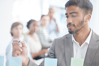Buy stock photo Shot of a young businessman writing on a transparent board at work