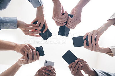 Buy stock photo Hands, business people and phones in circle, low angle and teamwork for networking in office. Colleagues, website and internet for social media research, solidarity and online unity for web survey