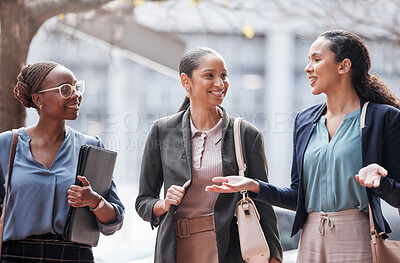 Buy stock photo Shot of a group of young businesswomen talking against a city background