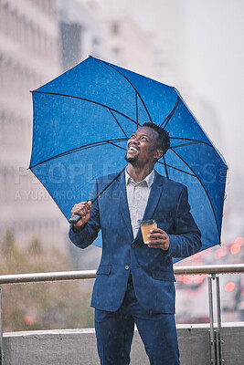 Buy stock photo Shot of a young businessman holding an umbrella in the rain against a city background