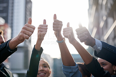 Buy stock photo Shot of a group of young businesspeople showing a thumbs up against a city background
