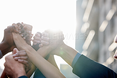 Buy stock photo Shot of a group of unrecognizable businesspeople holding hands against a city background