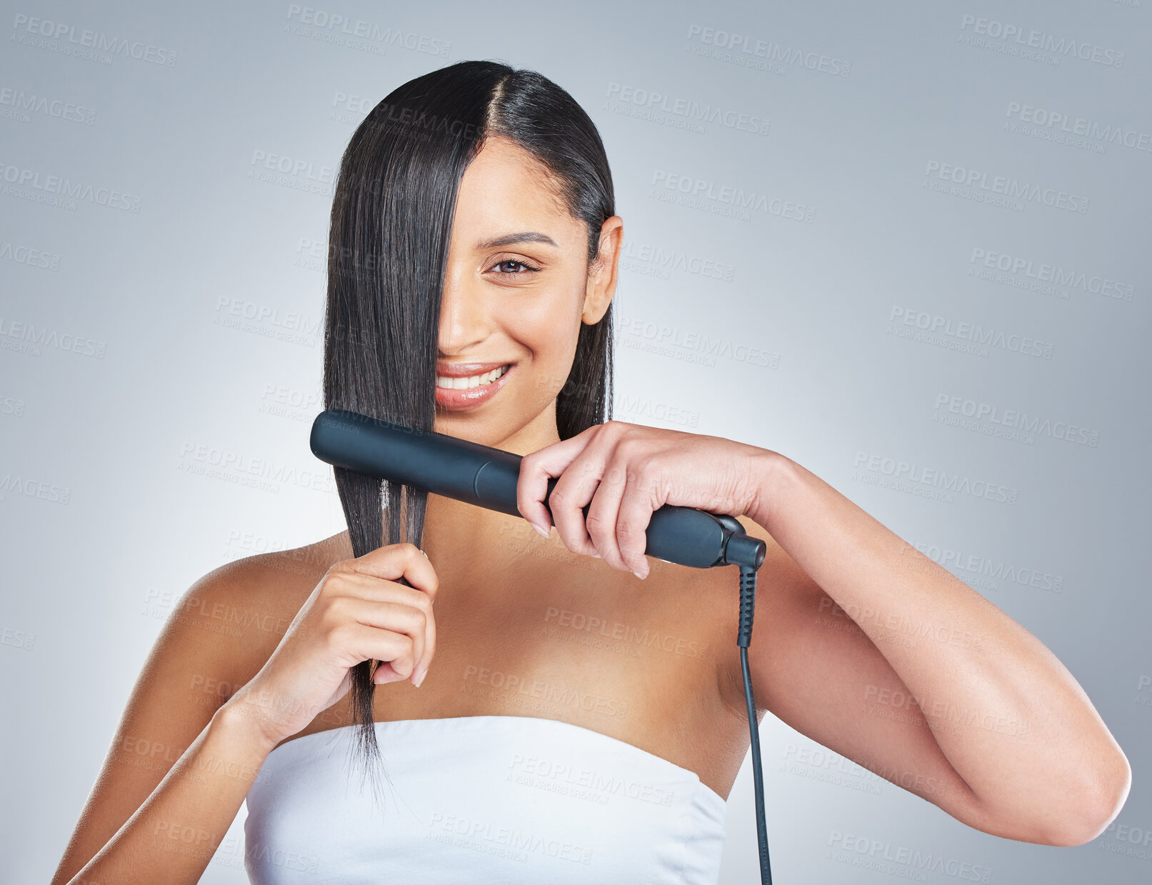 Buy stock photo Happy, portrait and girl with hair straightener in studio for style, treatment and shampoo shine results on grey background. Haircare, flat iron and face or woman model with beauty, texture or growth