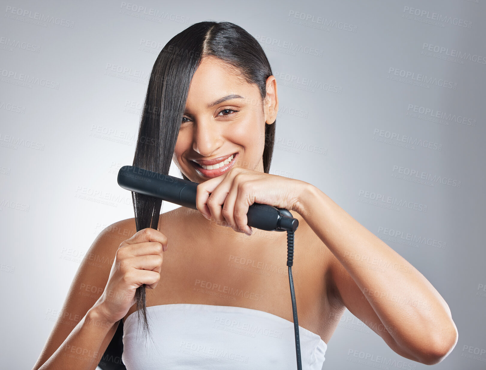 Buy stock photo Happy, portrait and woman with hair straightener in studio for style, treatment and shampoo shine results on grey background. Haircare, flat iron and face or girl model with beauty, texture or growth