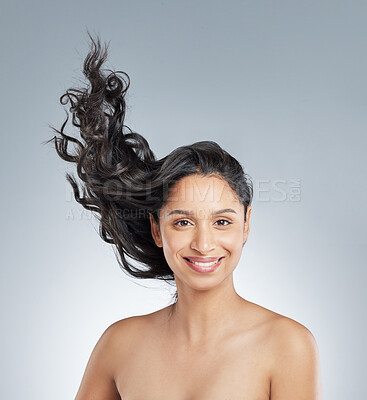 Buy stock photo Shot of an attractive young woman standing alone in the studio and flipping her hair