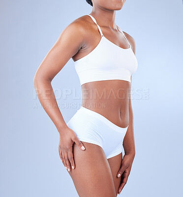 Buy stock photo Body, underwear and black woman with hand on thigh, wellness and exercise on blue studio background. African person, model and girl with beauty, healthy and fiber with fitness, training and workout