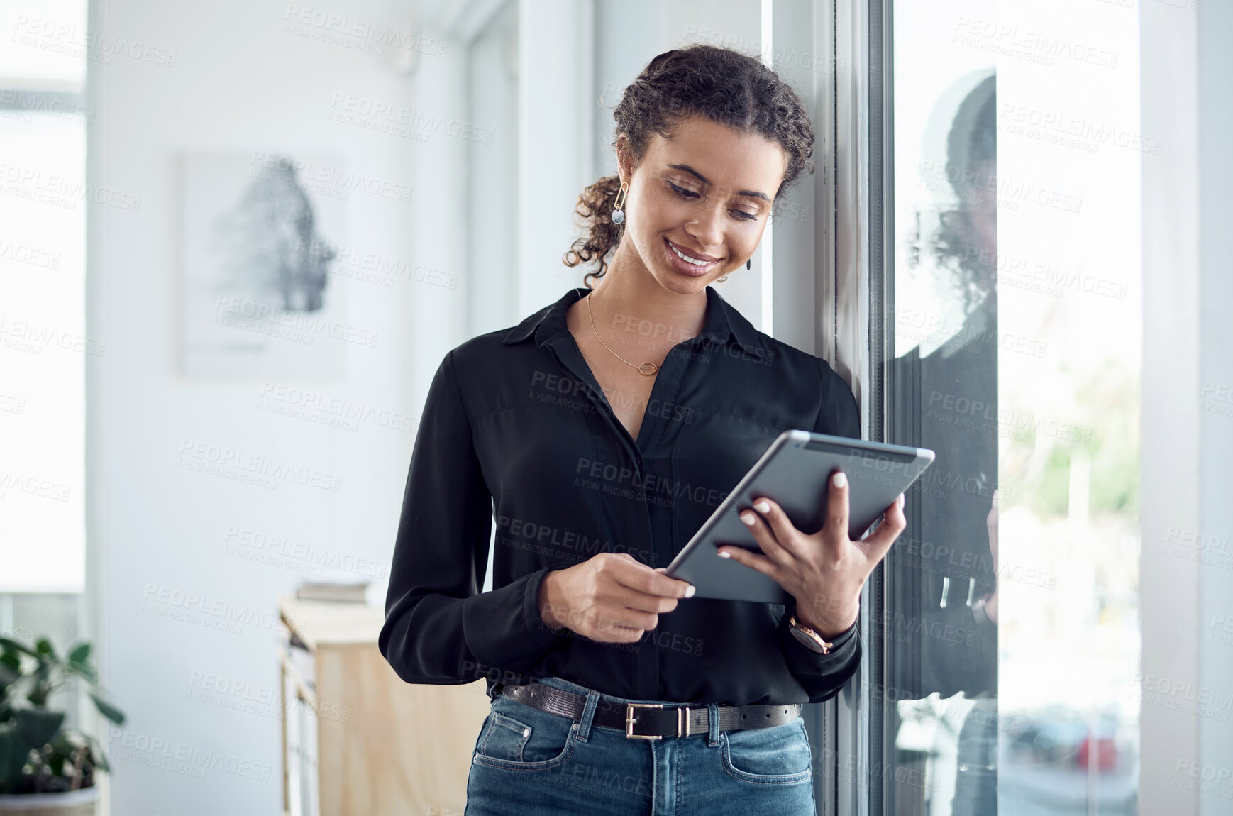 Buy stock photo Shot of a young businesswoman using a digital tablet in an office