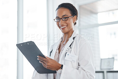 Buy stock photo Shot of a female young doctor recording a patients information on a clipboard