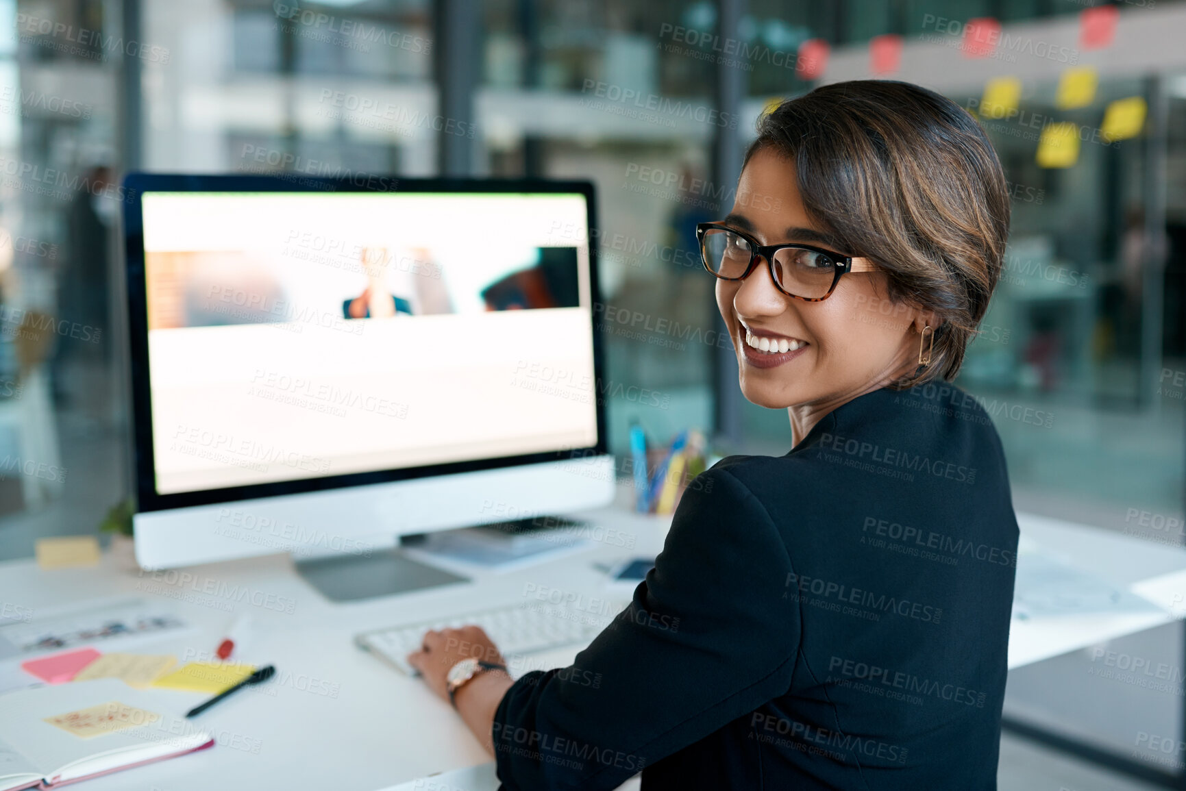 Buy stock photo Shot of an attractive young businesswoman sitting alone in the office and using her computer