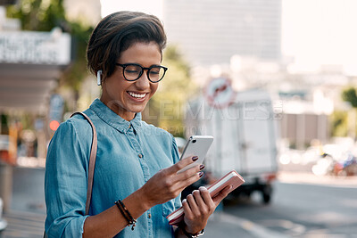 Buy stock photo Shot of an attractive young businesswoman standing alone and using her cellphone in the city