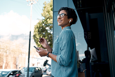 Buy stock photo Shot of an attractive young businesswoman standing alone outside and using her cellphone in the city