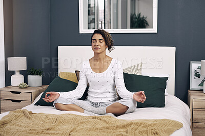 Buy stock photo Shot of an attractive young woman meditating on her bed at home