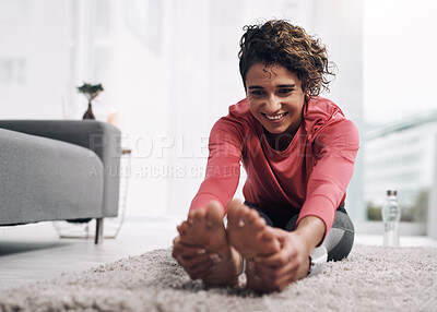Buy stock photo Shot of a young woman doing some warmup exercises on the floor at home