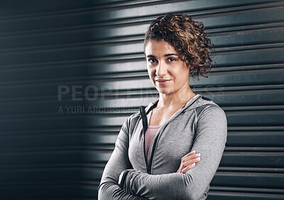 Buy stock photo Portrait of a young beautiful woman folding her arms against a black background