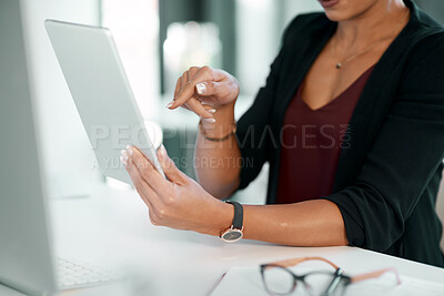 Buy stock photo Cropped shot of an unrecognisable businesswoman sitting alone in the office and using a digital tablet