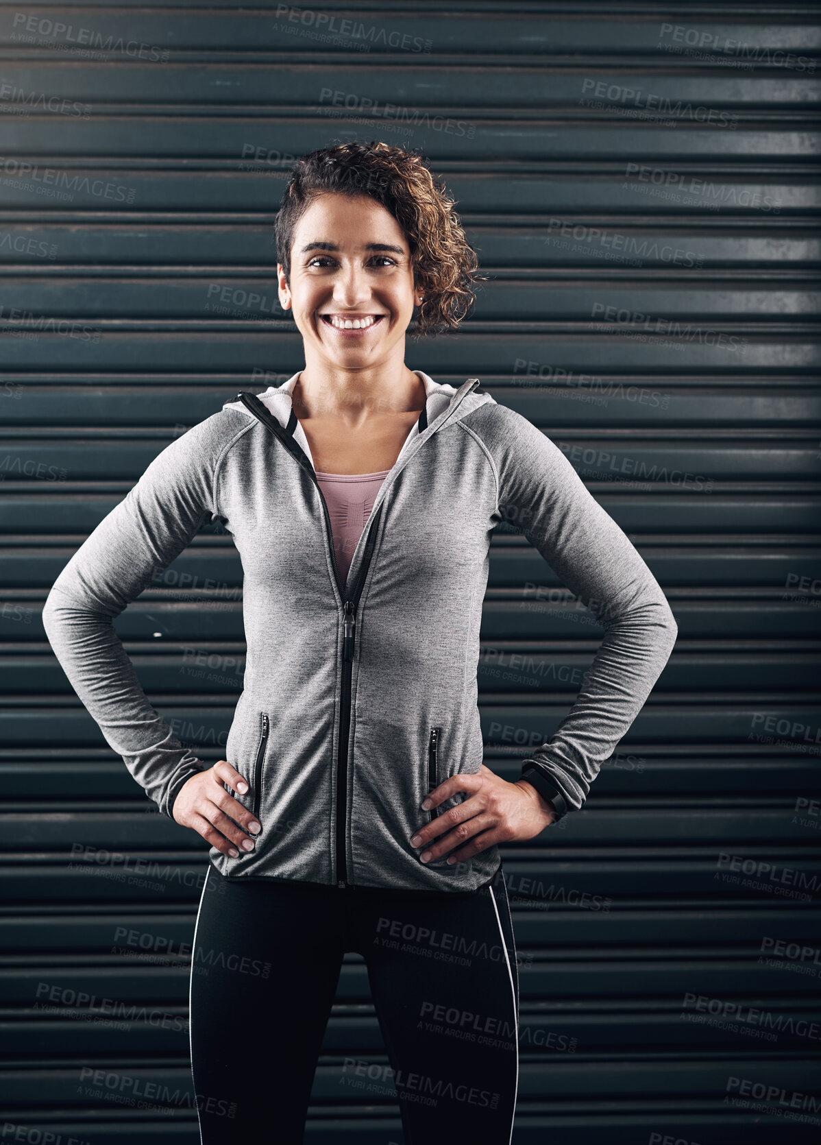 Buy stock photo Portrait of a young beautiful woman posing with her hands on her hips against a black background