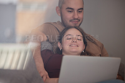 Buy stock photo Shot of a young couple relaxing and watching movies on a laptop