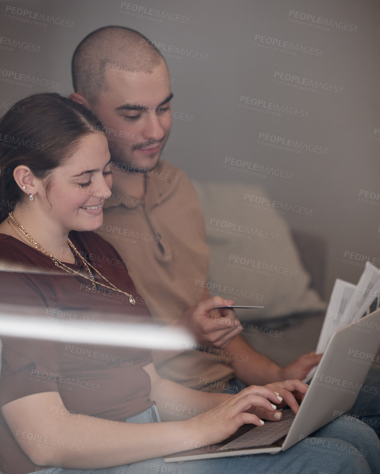 Buy stock photo Shot of a young couple paying bills together using a laptop