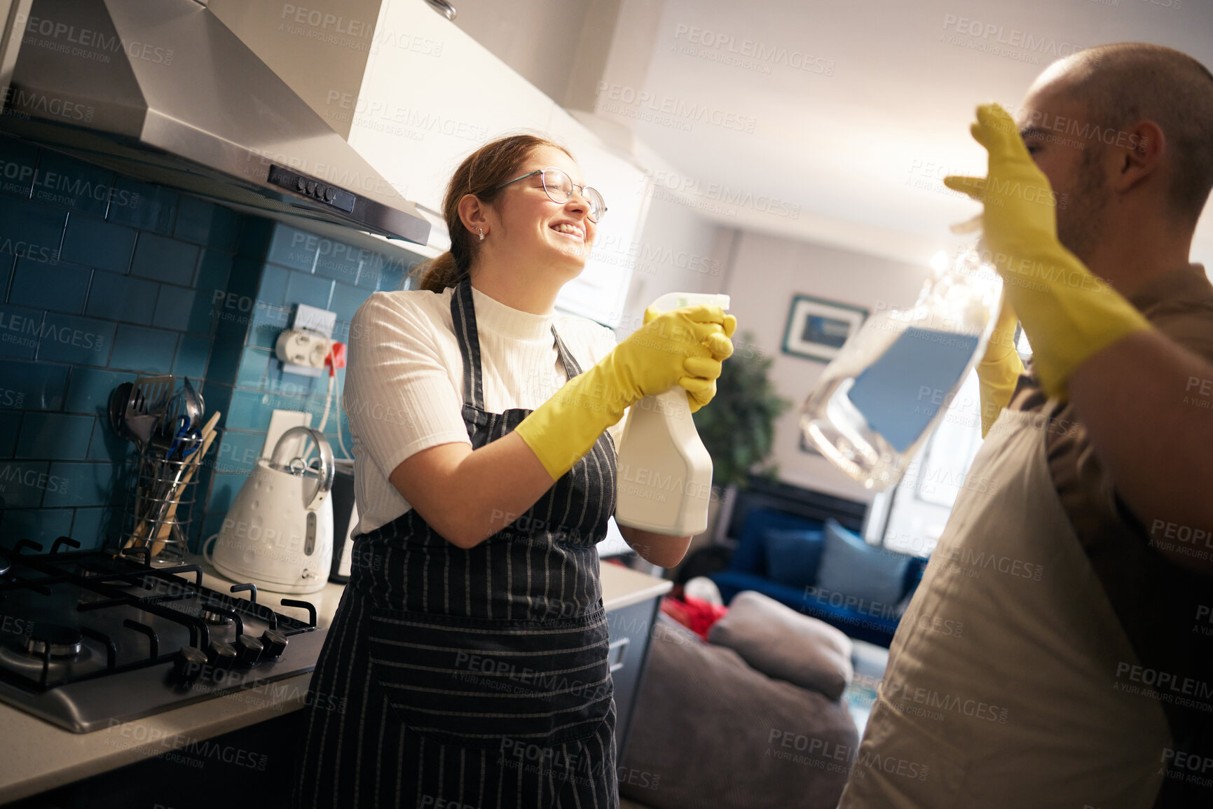 Buy stock photo Kitchen, cleaning and couple playing in home with spray bottle for bonding, relationship and fun together. Housekeeping, marriage and happy man and woman with detergents, disinfection and hygiene