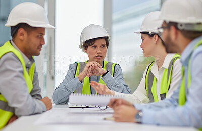 Buy stock photo Cropped shot of a group of young construction workers sitting around the boardroom table during a meeting