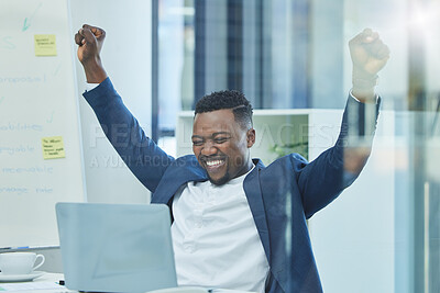 Buy stock photo Shot of a young businessman sitting at his desk cheering in excitement