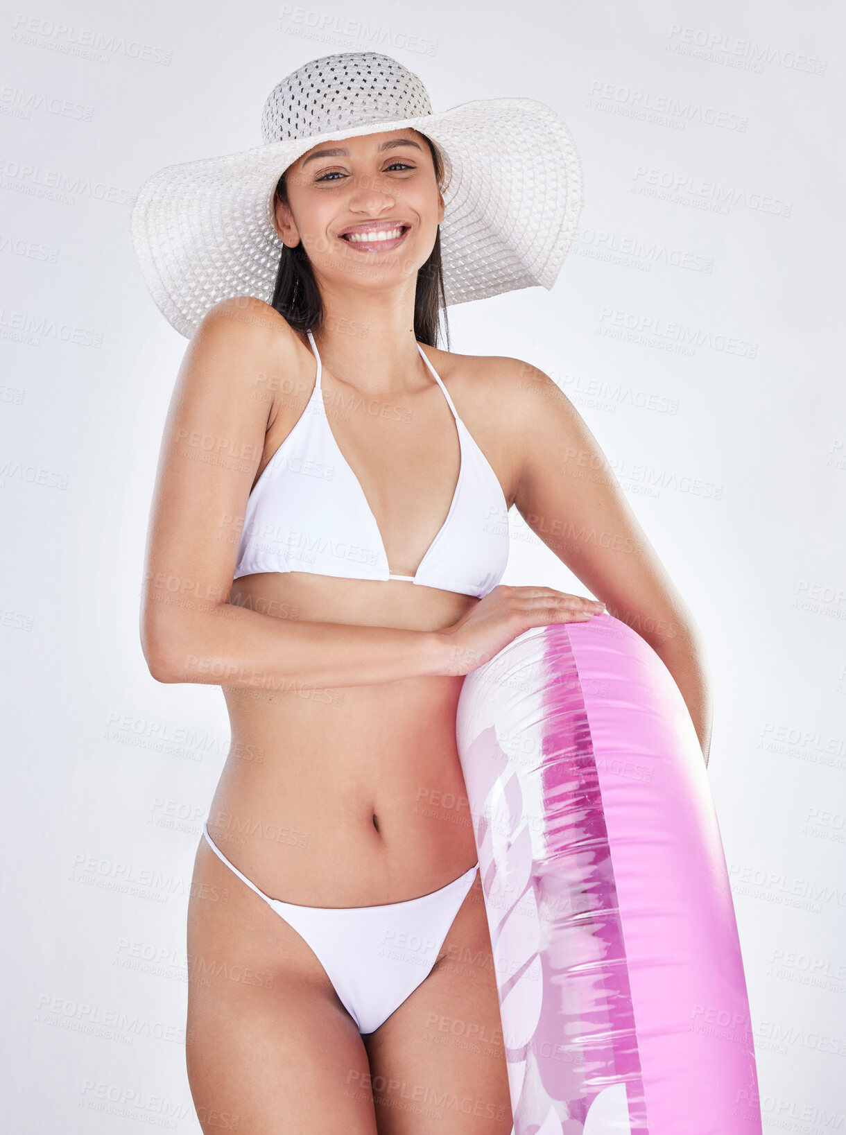 Buy stock photo Studio portrait of an attractive young woman posing in a bikini against a grey background