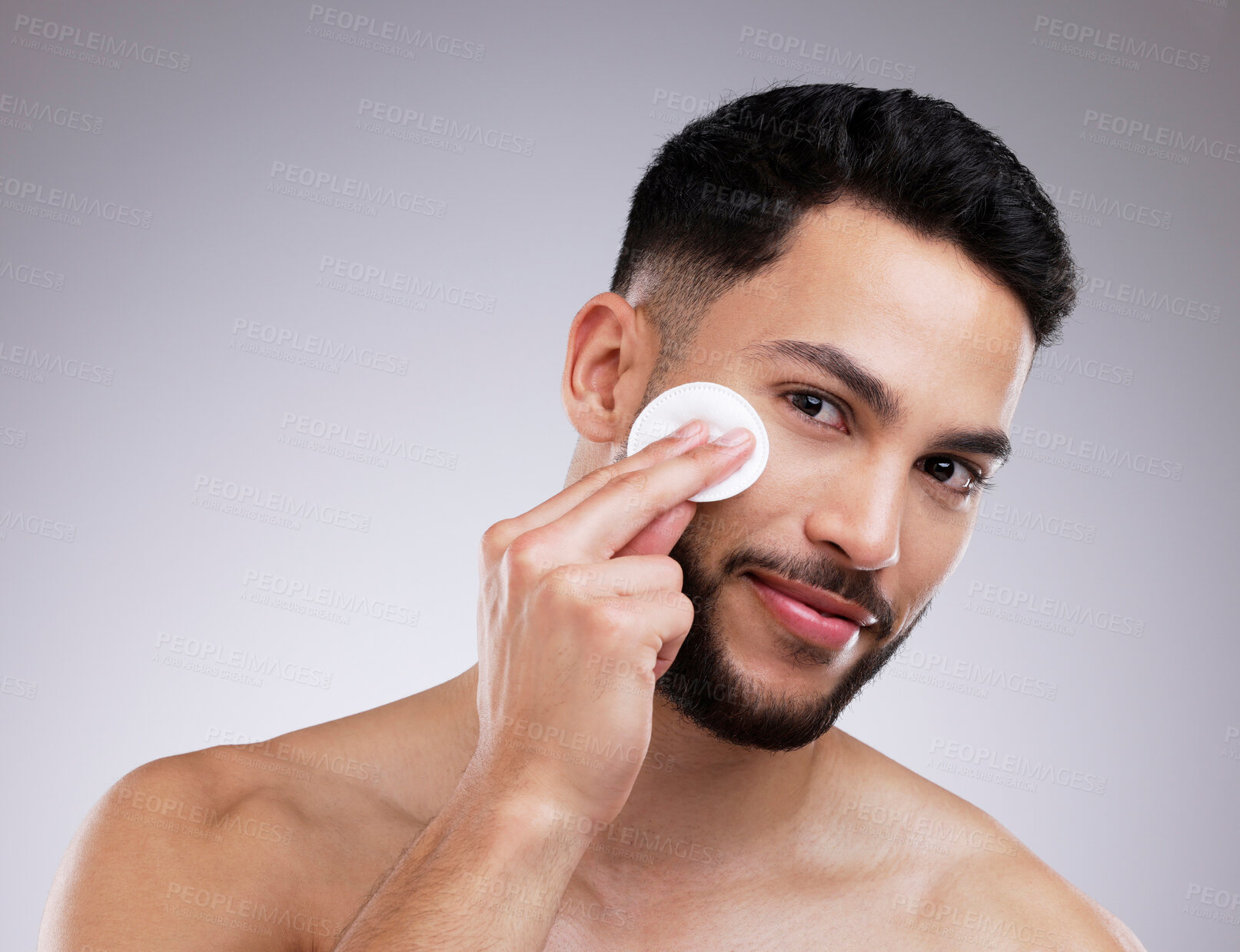 Buy stock photo Shot of a young man applying product to his face using a cotton pad