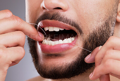 Buy stock photo Man, cleaning and teeth with floss in studio for oral hygiene, mouth care and fresh breath. Male person, morning routine and hand with dental product for gum health, protection and cavity prevention