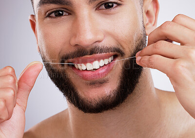 Buy stock photo Studio, portrait and man with floss, smile and dental care with confidence, protection and grooming. Mouth, health and happy male model cleaning teeth, gums and routine isolated on grey background.