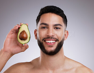 Buy stock photo Studio, portrait and man with avocado, skincare and smile with confidence, vitamin c and collagen. Cosmetics, facial health and happy male model with fruit, dermatology or grooming on grey background