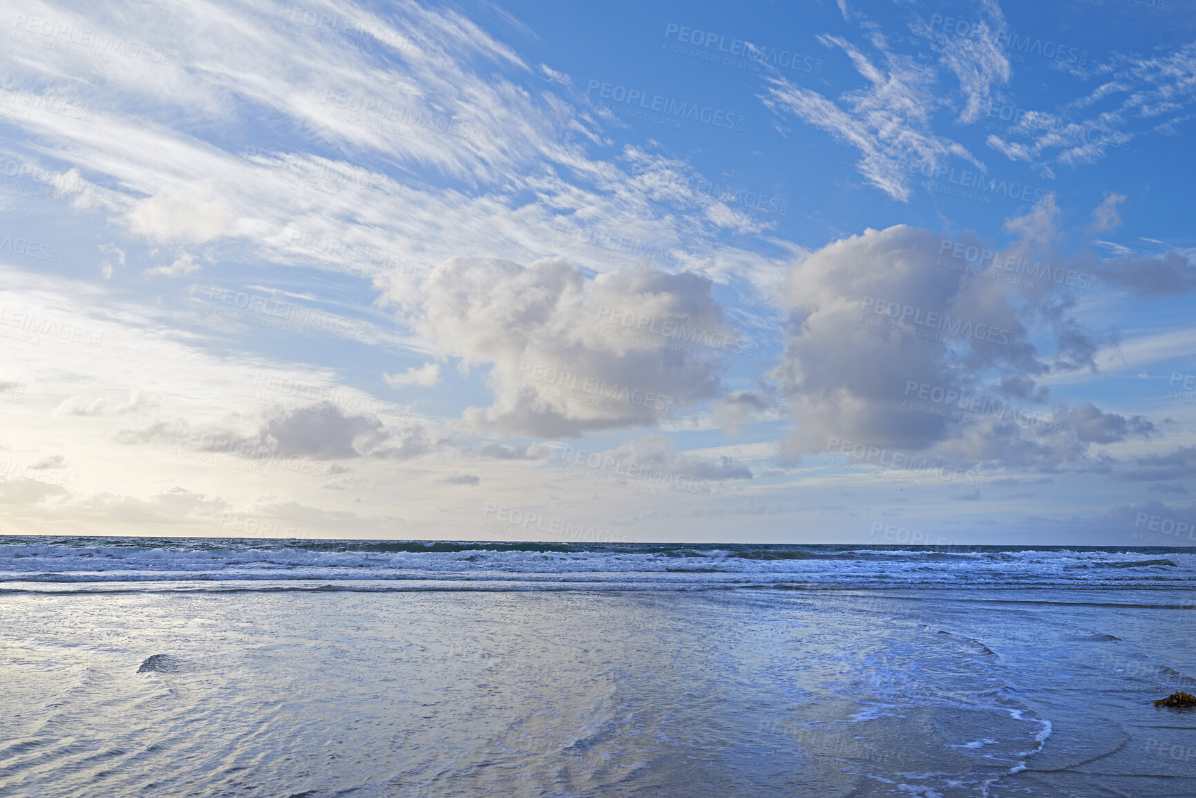 Buy stock photo Blue ocean view of calm sea water on a summer morning. Nature landscape of a relaxed coastline with a blue sky and white clouds in the background. Seaside scene of waves on a beautiful beach day.