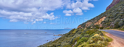 Buy stock photo Copy space with sea view and a street along the mountain against a cloudy sky background at the coast. Beautiful and scenic coastal landscape of nature to travel or explore on a peaceful road trip