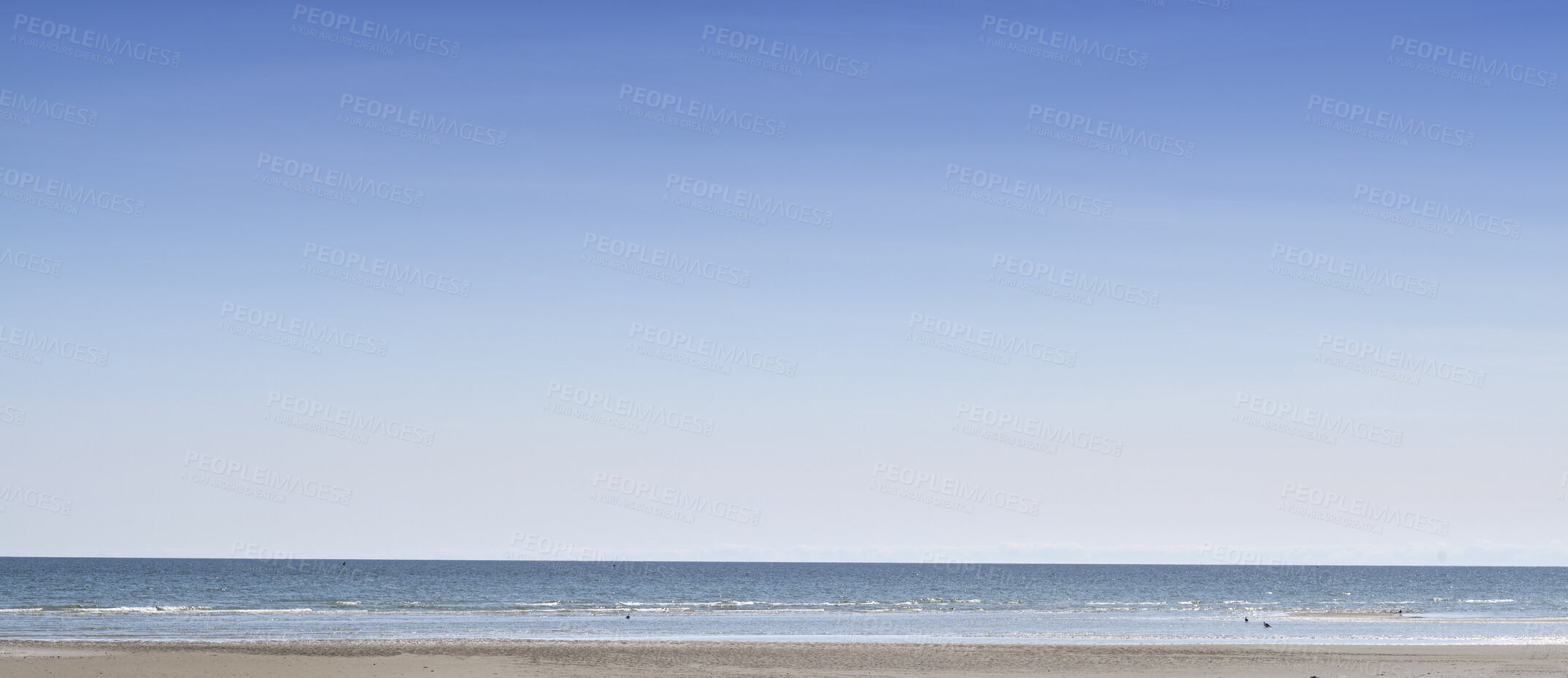 Buy stock photo Copy space at the sea with a clear blue sky background above the horizon. Panoramic of calm ocean waters across a beach shore. Peaceful scenic coastal landscape for a relaxing and zen summer getaway