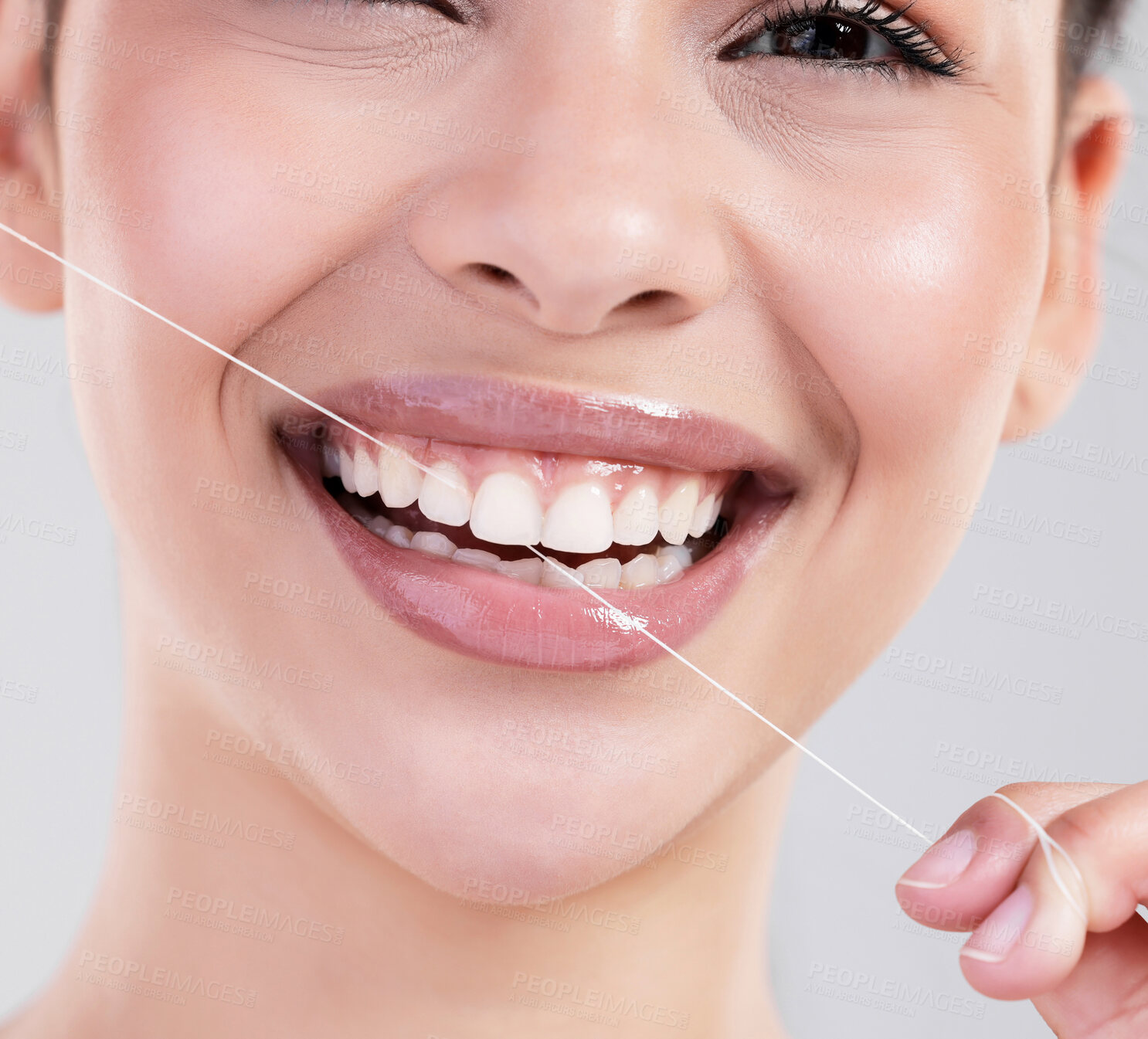 Buy stock photo Happy woman, portrait and closeup with dental floss for teeth cleaning, hygiene or treatment on a gray studio background. Young female person or model with big smile for oral, gum and mouth care