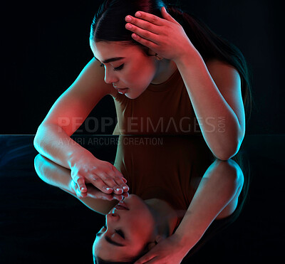 Buy stock photo Shot of an attractive young female ballerina practicing in a dark dance studio