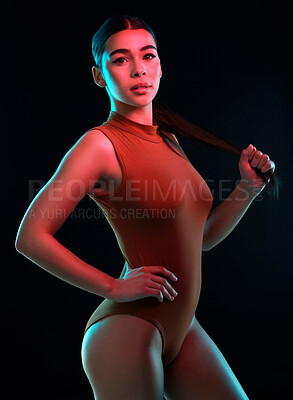 Buy stock photo Portrait of an attractive young female ballerina practicing in a dark dance studio