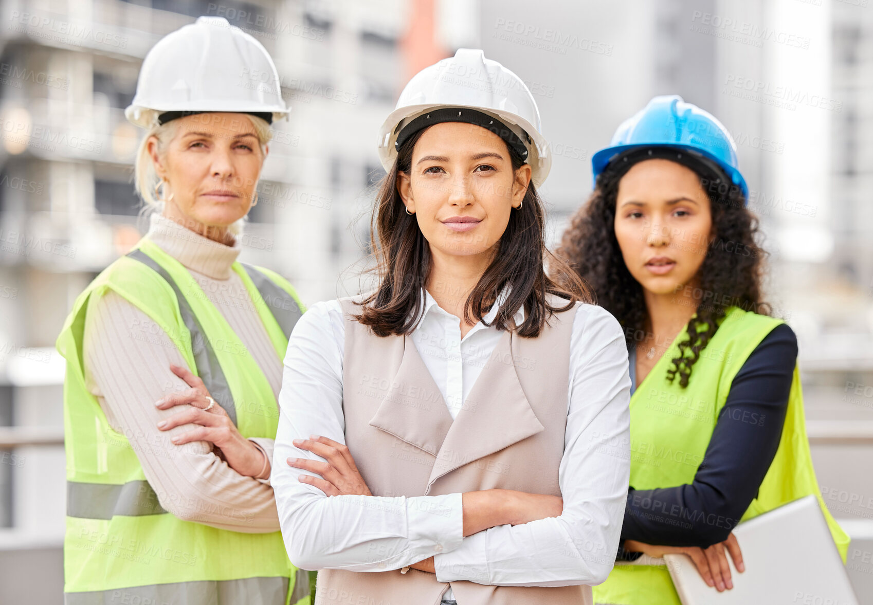 Buy stock photo Cropped portrait of three attractive female engineers standing with their arms folded on a construction site