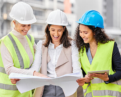 Buy stock photo Cropped shot of three attractive female engineers looking at blueprints while standing on a construction site