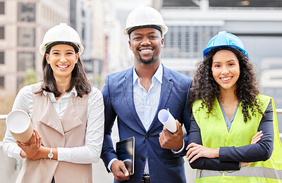 Buy stock photo Cropped portrait of three young engineers standing with blueprints on a construction site