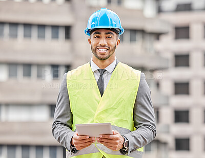 Buy stock photo Cropped portrait of a handsome young male engineer working on a tablet while standing on a construction site