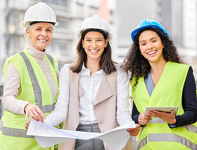 Buy stock photo Cropped portrait of three attractive female engineers looking at blueprints while standing on a construction site
