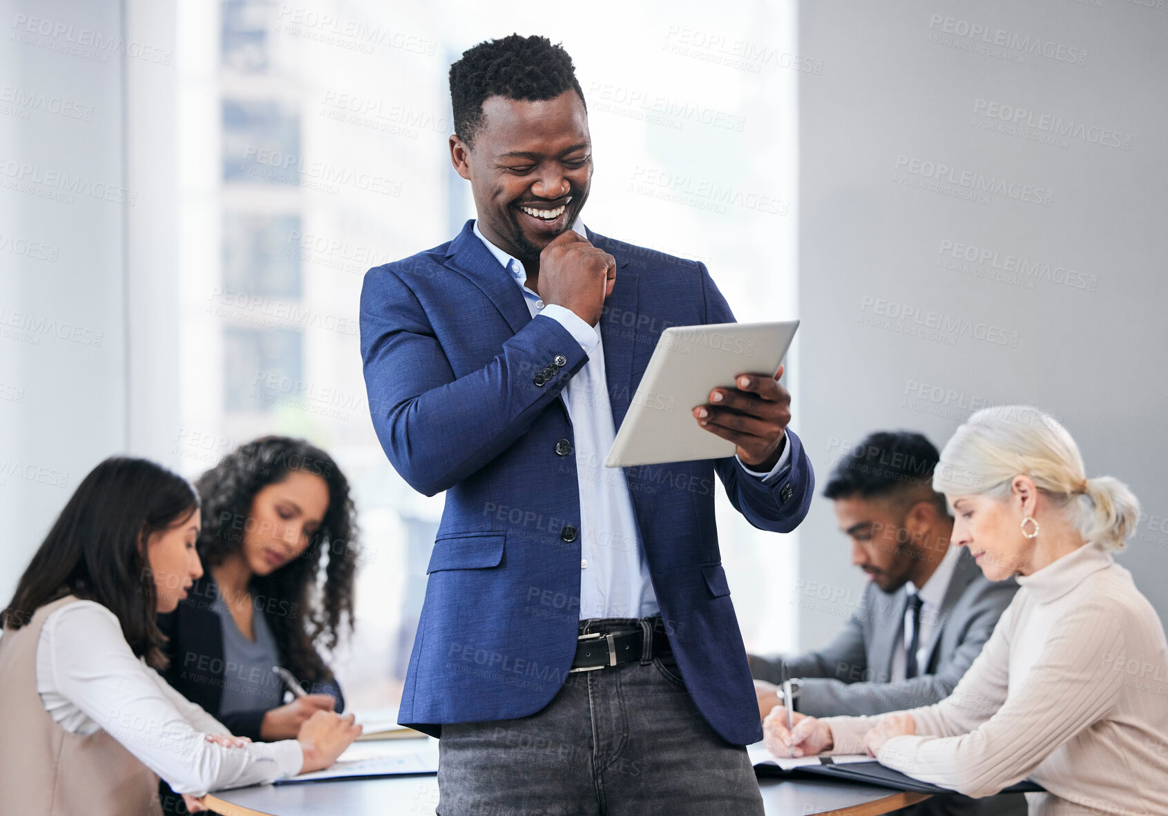 Buy stock photo Shot of a young businessman using a digital tablet during a business meeting