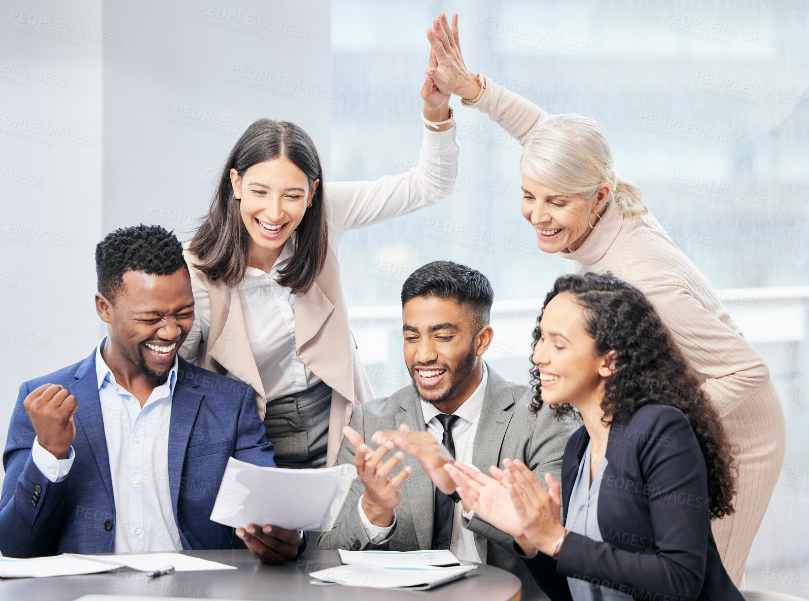 Buy stock photo Shot of a team of business people reading through documents during a meeting