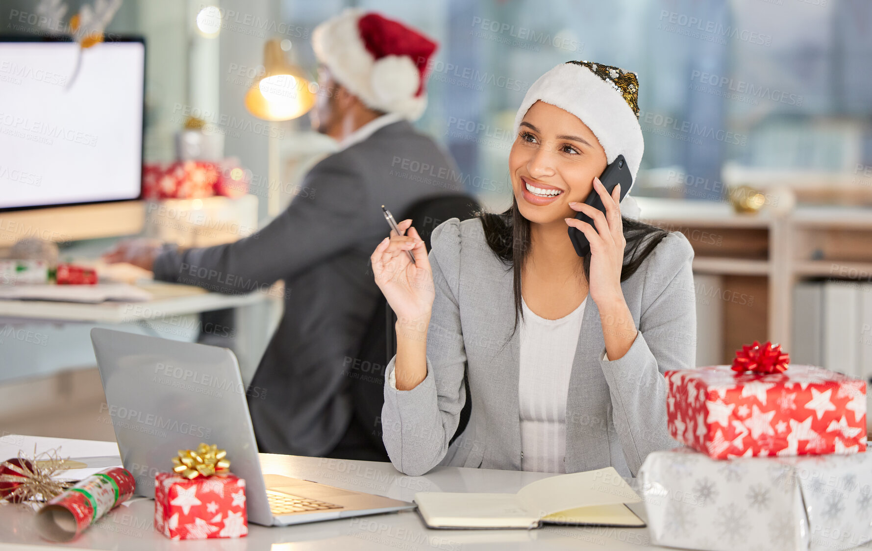 Buy stock photo Shot of a young businesswoman using a laptop and smartphone in a modern office at Christmas