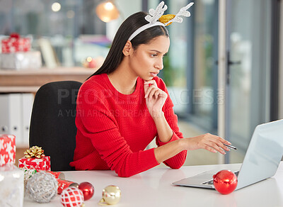 Buy stock photo Shot of a young businesswoman using a laptop in a modern office at Christmas